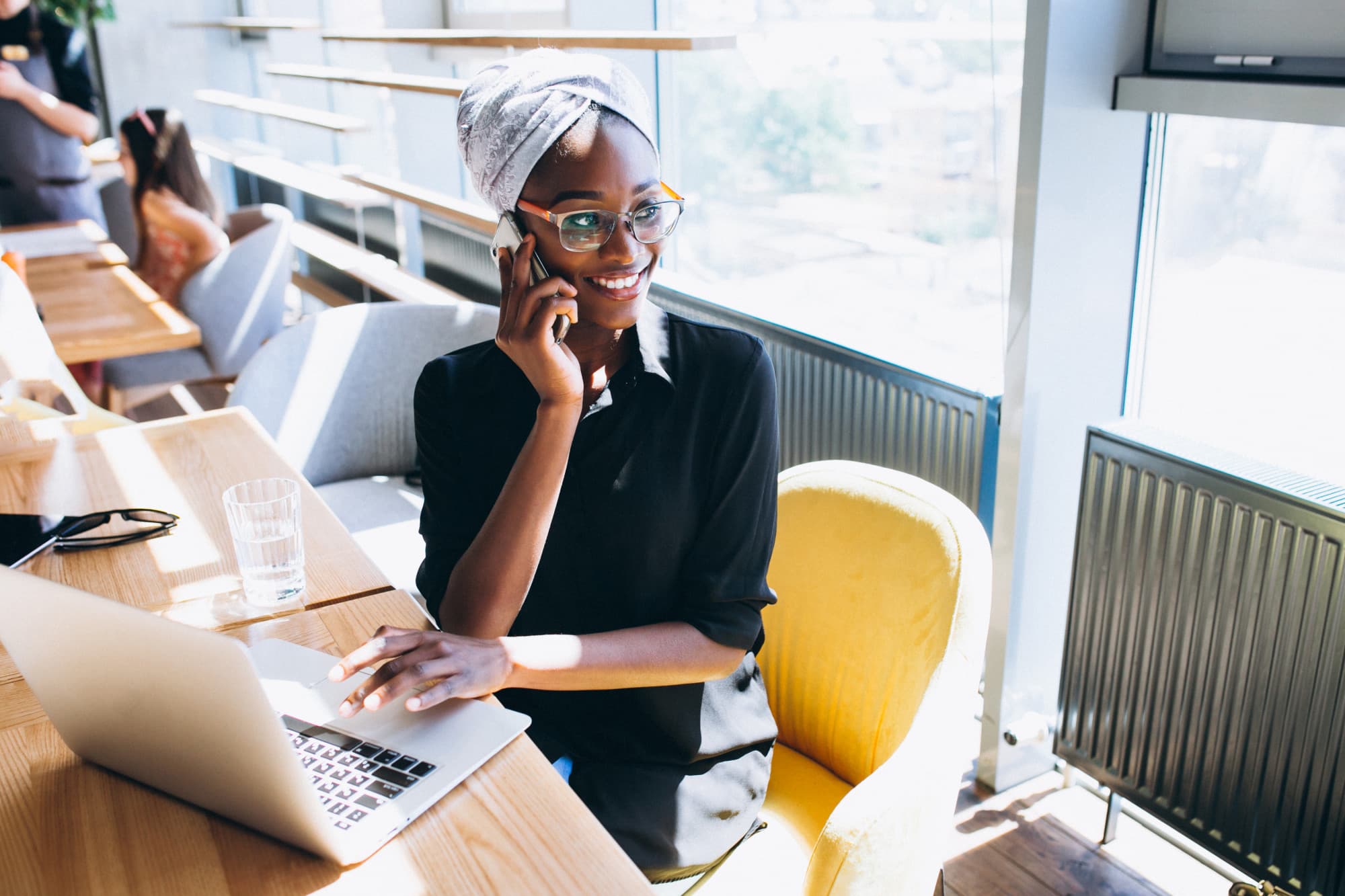 Nigerian businesswoman managing her books on a laptop and phone