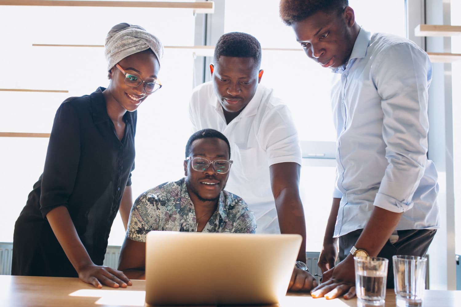 Nigerian team collaborating around a laptop in a Lagos office