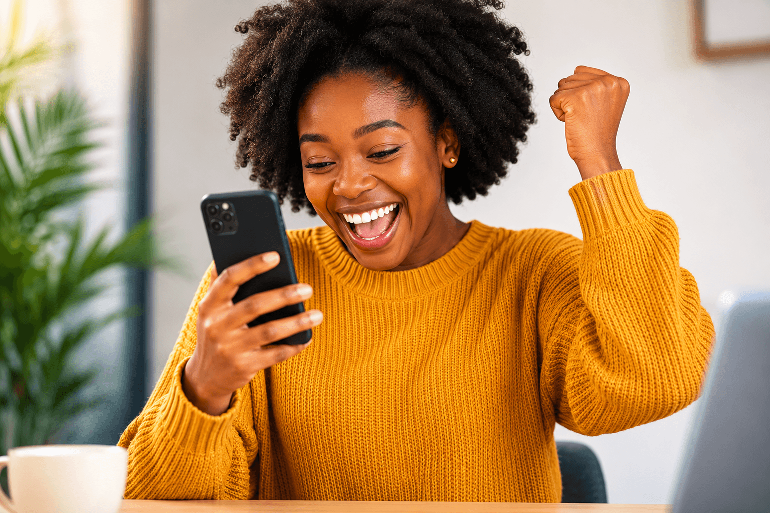 Excited Nigerian entrepreneur celebrating her campaign results on her phone